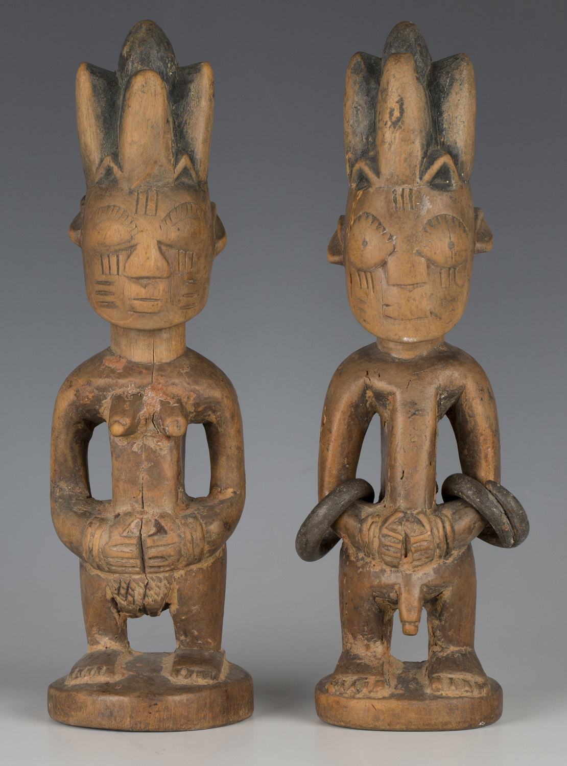 A pair of Yoruba Ere Ibeji carved wooden twin figures, modelled in the form of a male and female,