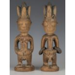 A pair of Yoruba Ere Ibeji carved wooden twin figures, modelled in the form of a male and female,
