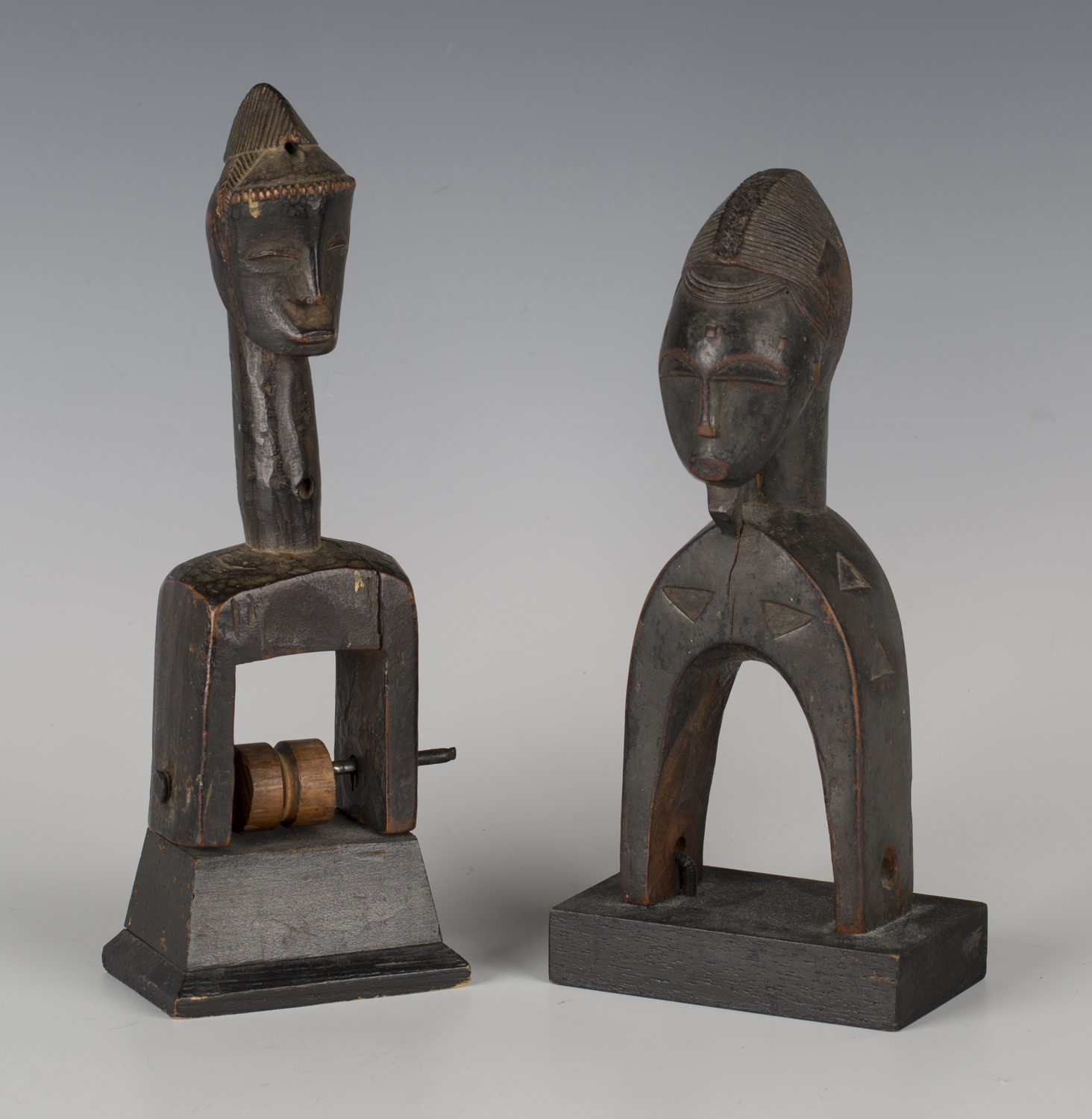 A Baule carved hardwood heddle pulley, Ivory Coast, together with another similar heddle pulley,