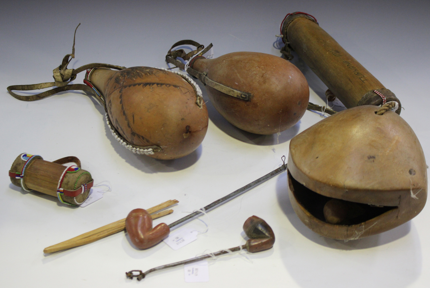 A group of African items, mostly Kenyan Maasai, including two pipes, two milk gourds, a hollowed