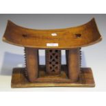 An Ashanti carved hardwood stool, the curved seat raised on four supports, width 33cm. Provenance:
