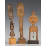Two African carved wooden staff finials of figural form, heights 26cm and 30cm, together with a