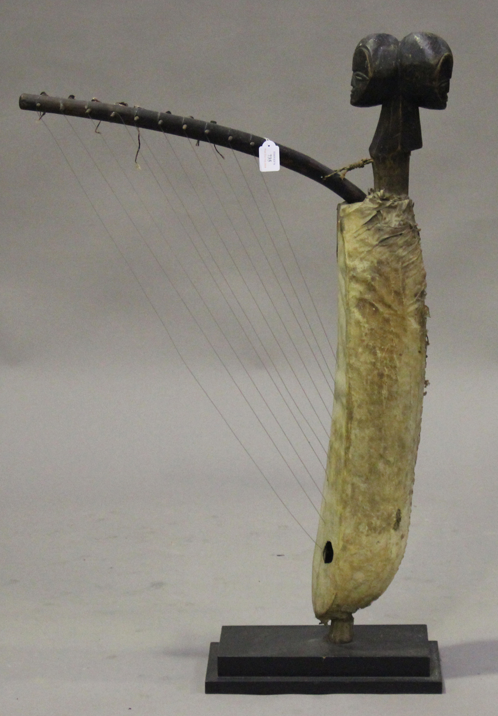 A Ngbaka harp, Democratic Republic of Congo, the double-headed mask finial above a hide-covered body