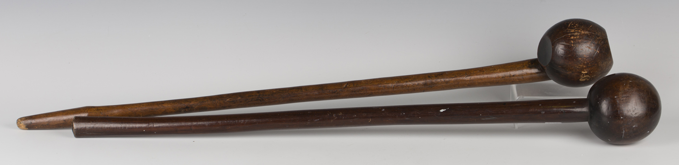 Two African hardwood knobkerries, typically carved with bulbous ends and tapering shafts, lengths