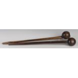 Two African hardwood knobkerries, typically carved with bulbous ends and tapering shafts, lengths