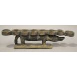 An African carved hardwood mancala board, modelled in the form of a stylized crocodile, raised on
