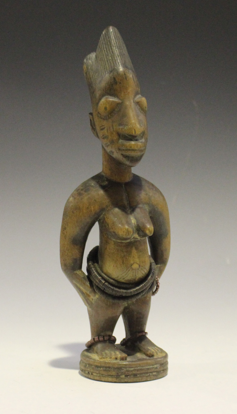 A Yoruba Ere Ibeji carved wooden female figure with applied bead bands, height 28.5cm. Provenance: