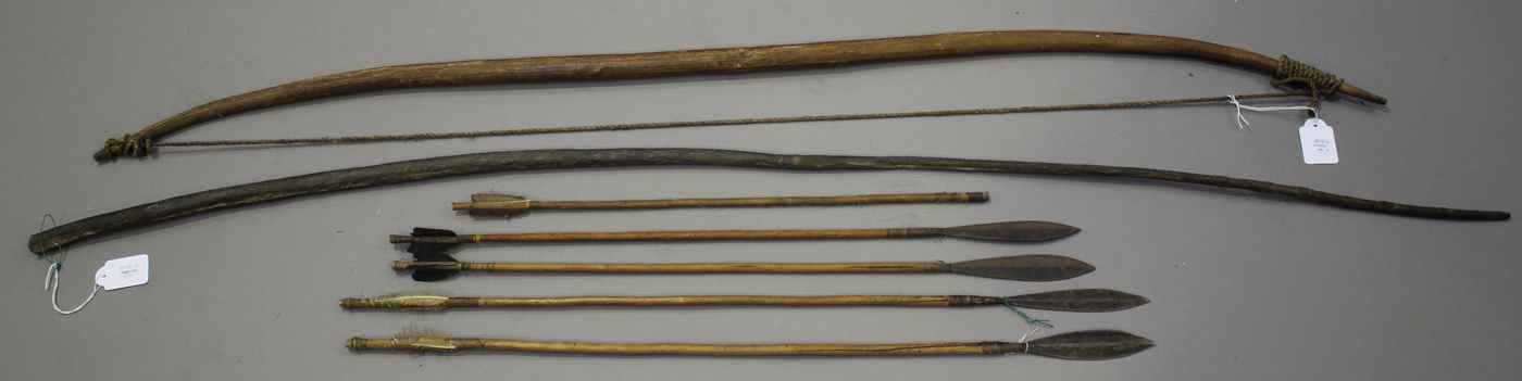 An African wooden bow, a group of five African arrows and an elephant's tail whip.Buyer’s Premium