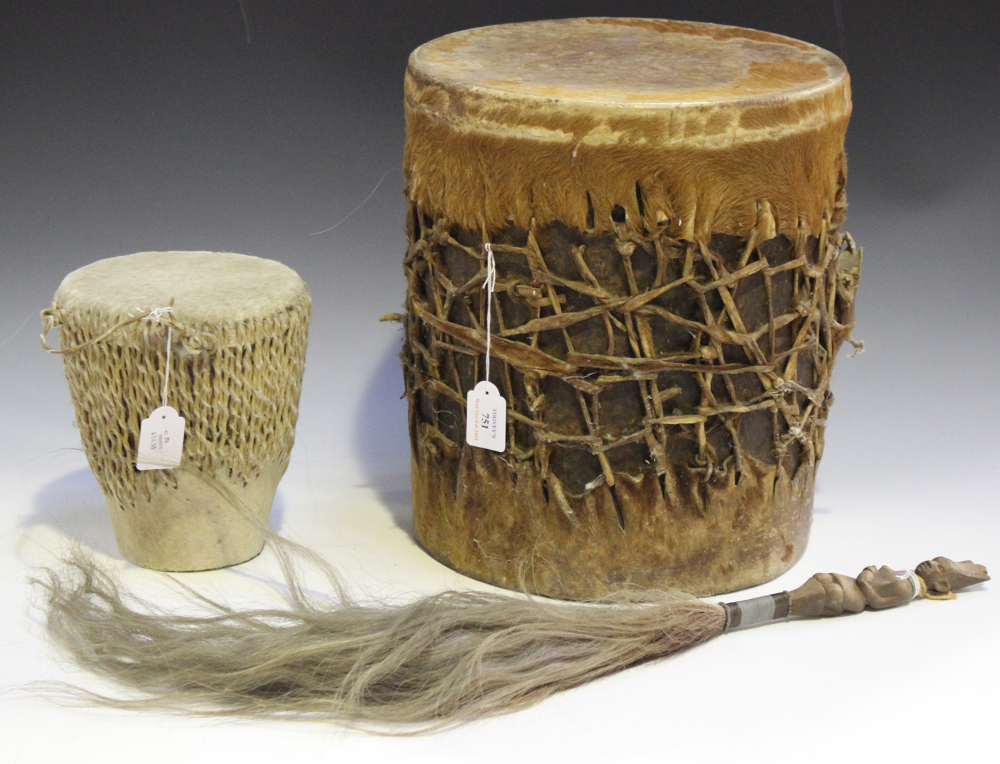 A Maasai cylindrical drum, Kenya, covered in animal hide, height 37cm, together with a smaller