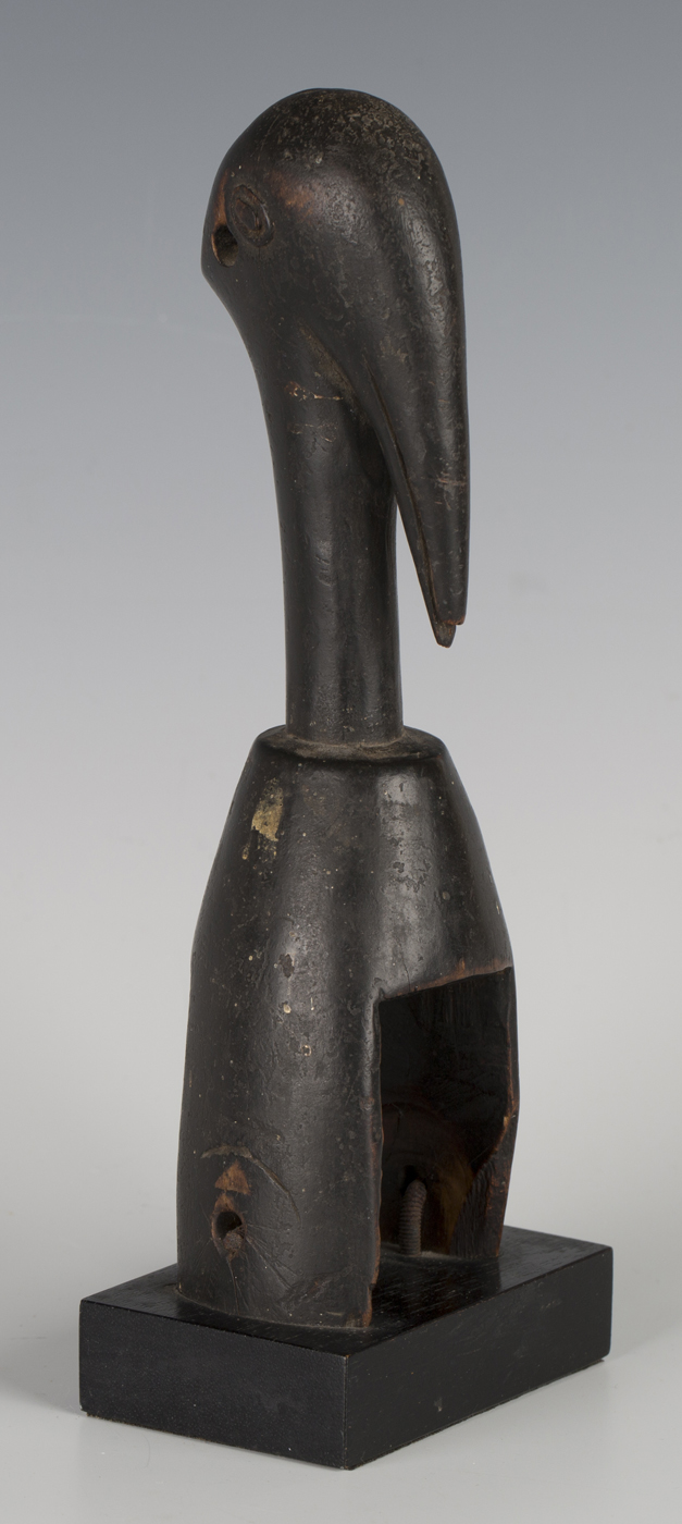 A Senufo carved hardwood heddle pulley, Ivory Coast, modelled as the head of a stylized hornbill