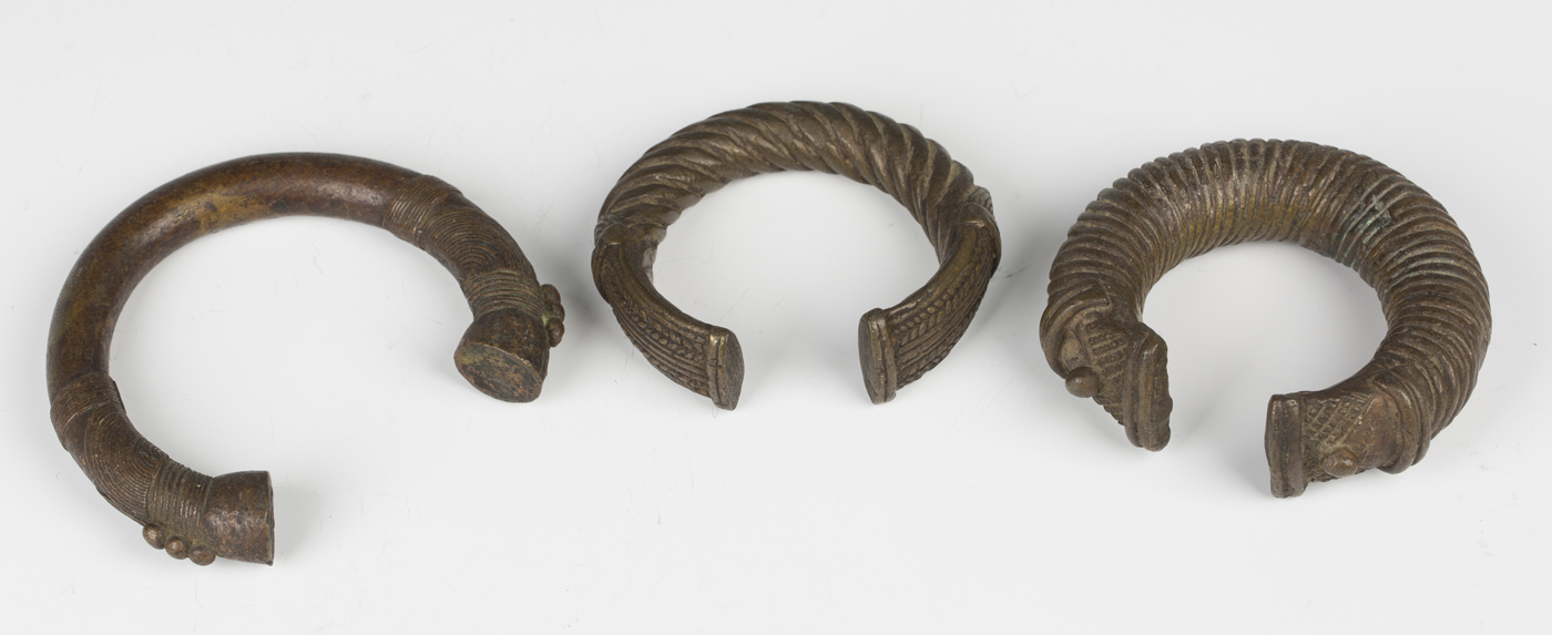 A group of three African patinated bronze currency manilla, all of typical curved form, widths 9.