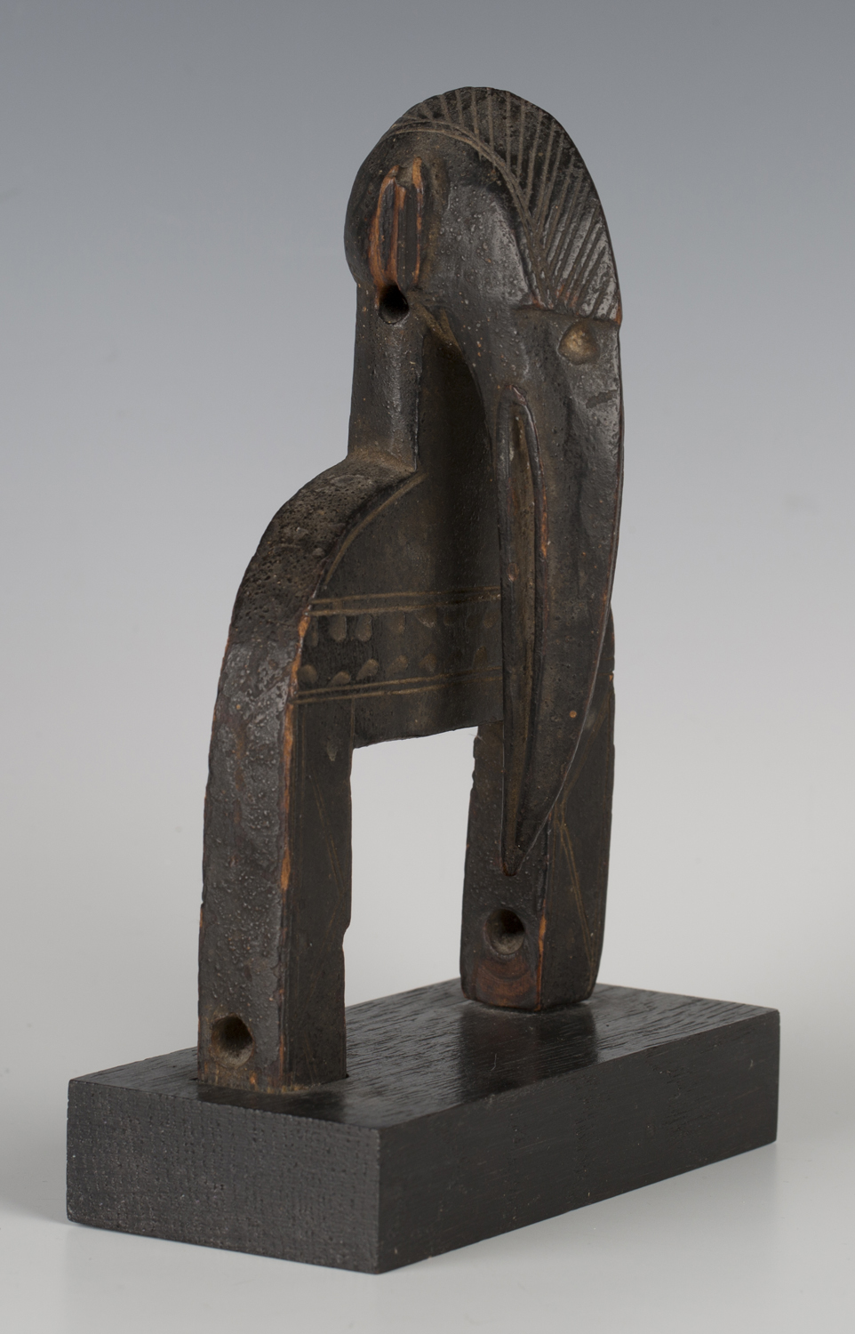 A Senufo carved heddle pulley, Ivory Coast, the finial modelled as the head of a hornbill with