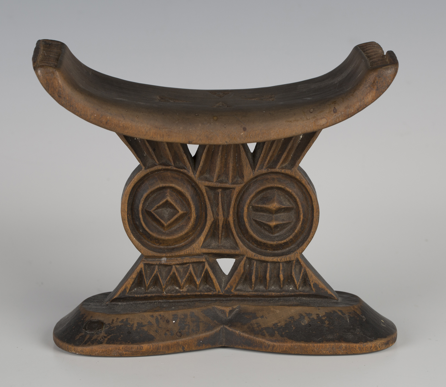 A Shona carved wooden headrest, Zimbabwe, the curved rectangular upper platform above a twin support