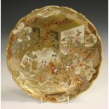 A Japanese Satsuma earthenware circular dish, Meiji period, painted and gilt with a figural scene