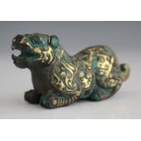 A Chinese gold inlaid cast bronze figure of a tiger, Han style but later, modelled in a crouching