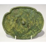 A Chinese archaic bronze quatrefoil shaped mirror, probably Tang dynasty, one side cast with a