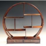 A Chinese hardwood circular display stand, 20th century, the circular openwork frame supporting an