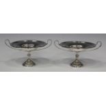 A pair of Edwardian silver bonbon tazze, each shallow circular bowl flanked by two slender scroll