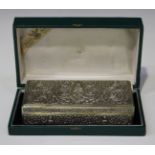 A 20th century Thai sterling rectangular cigarette box, decorated in relief with deities and