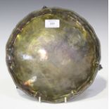 A George III silver circular card salver with raised beaded rim, on claw and ball feet, London