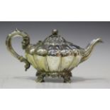 An early Victorian silver teapot of melon form with melon and leaf finial, foliate capped scroll