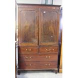 A George III mahogany linen press, the moulded pediment above a pair of panelled doors with