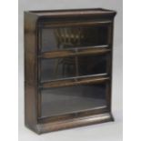 An early 20th century oak Globe Wernicke style three-section glazed bookcase, on a shaped plinth