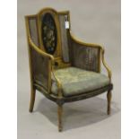 An early 20th century George III style satin walnut bergère armchair, the panelled back painted with