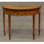 A George III satinwood demi-lune fold-over card table, inlaid with overall fan paterae and laurel