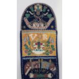 A Victorian beadwork and velvet wall pocket, the curved top panel worked with a regimental crest and