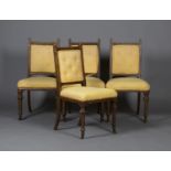 A set of four late Victorian Gothic Revival oak framed dining chairs with upholstered seats and