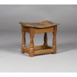 A Robert 'Mouseman' Thompson oak stool, the dished burr wood seat raised on chamfered block and