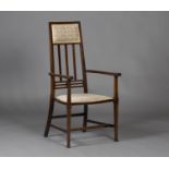 An Edwardian Arts and Crafts mahogany framed armchair, the slatted back above a padded seat,