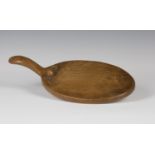A Robert 'Mouseman' Thompson oak cheese board, the oval platter with typical carved mouse