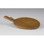 A Robert 'Mouseman' Thompson oak cheese board, the oval platter with raised handle carved with