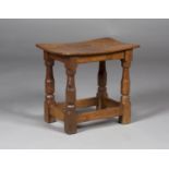 A Robert 'Mouseman' Thompson oak stool, the slightly dished seat raised on chamfered block and