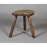 A Robert 'Mouseman' Thompson oak three-legged stool, the shaped seat raised on octagonal staked