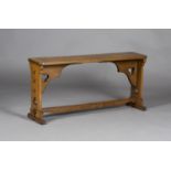 An Arts and Crafts oak bench, the rectangular top raised on a pair of trefoil pierced supports