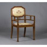 An Edwardian Arts and Crafts oak framed elbow chair, probably Glasgow School, the canted rectangular