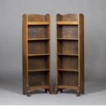 A pair of early 20th century Arts and Crafts oak open bookcases, designed by Ambrose Heal, the