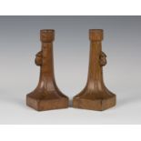 A pair of Robert 'Mouseman' Thompson oak candlesticks, each octagonal sconce above a flared stem,