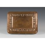 An early 20th century Arts and Crafts Newlyn School copper rectangular tray, the centre with a