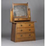 An Edwardian Arts and Crafts oak dressing chest, possibly Liberty & Co, the swing mirror on