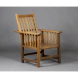 An early 20th century Arts and Crafts style pale oak reclining armchair, the slatted back above a