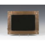 An early 20th century Arts and Crafts copper mounted rectangular wall mirror, the hammered frame