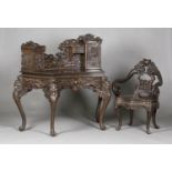 A Chinese carved wood writing desk and chair, late 19th century, the desk with carved dragon gallery