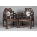 A pair of impressive Chinese hardwood armchairs, late Qing dynasty, each back inset with a