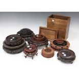 A collection of nine Chinese carved wood stands, 19th century and later, of various sizes, diameters