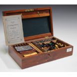 A late Victorian mahogany cased games compendium, the hinged lid revealing a chess set, draughts,