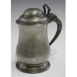 An 18th century pewter tappit lidded tankard of baluster form, the domed lid with shaped thumbpiece,